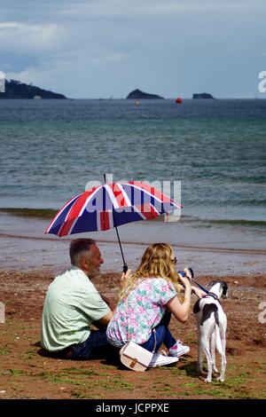 Paar aus der Sommer-Nieselregen unter einem Union Jack Dach auf 2016 Torbay Airshow bergende. Paignton, Devon, UK. Juni 2016. Stockfoto