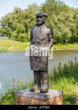 Statue von Lachs Fischer am Wall der Festungsstadt Woudrichem und Fluss Afgedamde Maas, Niederlande Stockfoto