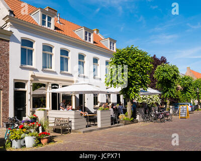 Menschen genießen auf der Terrasse des Cafés in der Altstadt der befestigten Stadt Woudrichem, Brabant, Niederlande Stockfoto