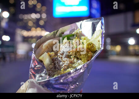 Falafel Sandwich Streetfood eingewickelt in Alufolie in der Nacht New York City USA Stockfoto