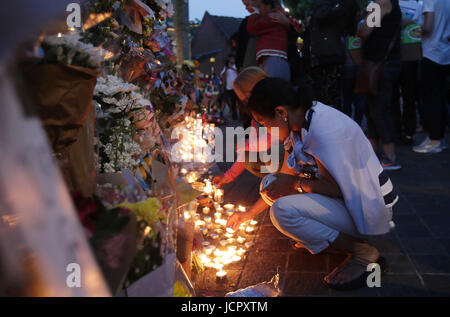 Leute betrachten Blumen und Hommagen außerhalb Notting Hill Methodist Church, in der Nähe von Grenfell Turm im Westen von London nach einem Feuer verschlungen das 24-geschossige Gebäude am Mittwochmorgen. Stockfoto