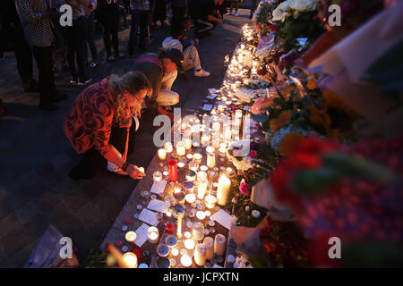 Leute betrachten Blumen und Hommagen außerhalb Notting Hill Methodist Church, in der Nähe von Grenfell Turm im Westen von London nach einem Feuer verschlungen das 24-geschossige Gebäude am Mittwochmorgen. Stockfoto
