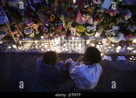 Leute betrachten Blumen und Hommagen außerhalb Notting Hill Methodist Church, in der Nähe von Grenfell Turm im Westen von London nach einem Feuer verschlungen das 24-geschossige Gebäude am Mittwochmorgen. Stockfoto