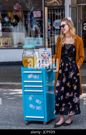 Frau mit Eistee trinken Dispenser, italienische Festivaltage Commercial Drive, Vancouver, Britisch-Kolumbien, Kanada. Stockfoto