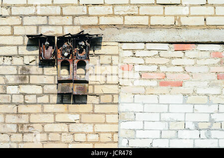 Verlassene Gebäude. Zerstörte alte Alarmsystem auf der alten Backsteinfassade. Alte Ziegel Wand Textur Stockfoto