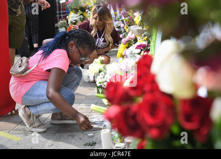 (Elterliche Einwilligung) Avigail Cunningham 9, zündet eine Kerze neben Ehrungen Notting Hill Methodist Church in der Nähe von Grenfell Turm im Westen Londons, nachdem ein Feuer verschlungen das 24-geschossige Gebäude am Mittwochmorgen. Stockfoto