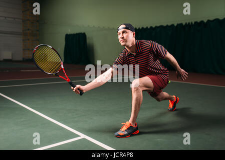 Mann mit Tennisschläger spielen auf Hallenplatz. Sport Training der Tennisspieler Stockfoto