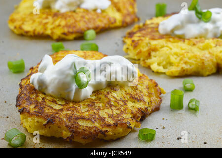 Spaghetti squash gebratene Kuchen mit saurer Sahne und Frühlingszwiebeln auf einem Metal-Brett Stockfoto