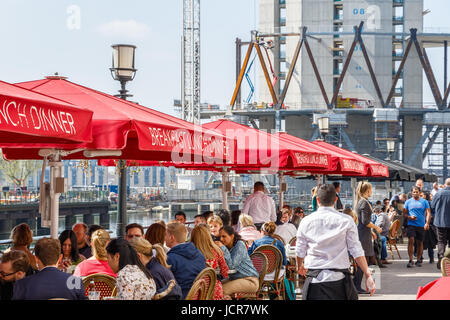 London, UK - 10. Mai 2017 - Dockside Restaurant in Canary Wharf voll mit Menschen, die Essen an einem sonnigen Tag Stockfoto