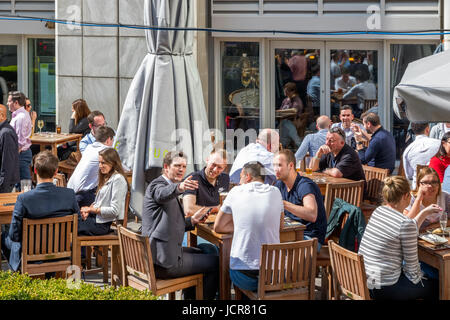 London, UK - 10. Mai 2017 - eine outdoor-Bar in Canary Wharf voller Leute trinken und plaudern Geschäft an einem sonnigen Tag Stockfoto