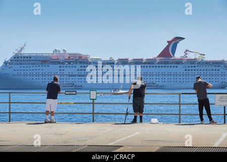 Sportfischer auf den Cabrillo-Maulwurf In Avalon, mit Blick auf die riesigen Kreuzfahrtschiff, Karneval Inspiaration, Avalon Hafen, Insel Catalina verankert. Stockfoto