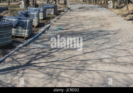 Reparatur von Bürgersteig in einem Stadtpark oder Garten mit Steinblöcken. Pflaster-Rekonstruktion Stockfoto