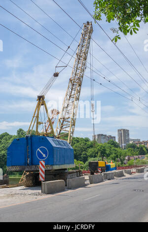 Modernisierung und Instandsetzung des Automobils Brücke über den Fluss. Brücke im Bau, Gebäude mit Kränen und anderen Geräten Stockfoto