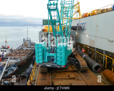 Das Deck legen Lastkahn. Rohre und heben Kräne auf dem Schiff. Ausrüstung für die Verlegung einer Pipeline auf dem Meeresboden. Stockfoto