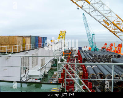 Das Deck legen Lastkahn. Rohre und heben Kräne auf dem Schiff. Ausrüstung für die Verlegung einer Pipeline auf dem Meeresboden. Stockfoto