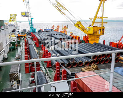 Das Deck legen Lastkahn. Rohre und heben Kräne auf dem Schiff. Ausrüstung für die Verlegung einer Pipeline auf dem Meeresboden. Stockfoto