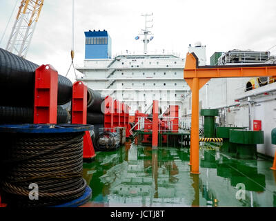 Das Deck legen Lastkahn. Rohre und heben Kräne auf dem Schiff. Ausrüstung für die Verlegung einer Pipeline auf dem Meeresboden. Stockfoto