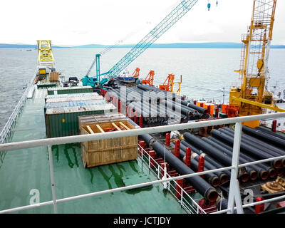 Das Deck legen Lastkahn. Rohre und heben Kräne auf dem Schiff. Ausrüstung für die Verlegung einer Pipeline auf dem Meeresboden. Stockfoto