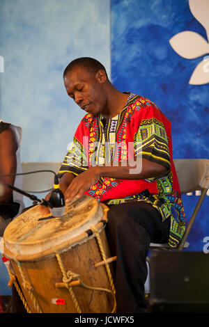 Afrikanischer Mann spielt traditionelle afrikanische Trommel auf der Bühne - USA Stockfoto