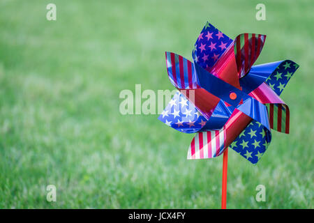 Wind-Spinner mit unscharfen Grasgrün.  4th of July. Tag der Arbeit Hintergrund. Stockfoto