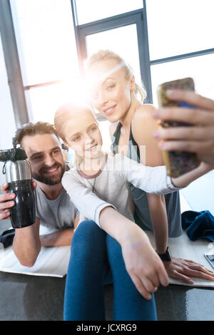 Mädchen, das Selbstporträt mit Eltern im Fitness-center Stockfoto