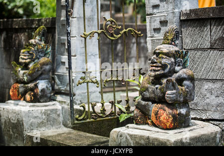 Balinesische Statuen, einzigartige Bildnisse geschnitzt aus Stein bewachen den Eingang zu einem Hindu-Tempel. Balinesische Statuen in der Hindu-Religion sind gemeinsame Stelle Stockfoto