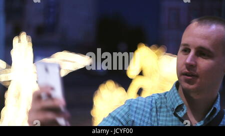 Menschen nehmen Foto mit Kamera-Handy in der Nacht. Lässige Jüngling unter Bild mit Kamera-Handy auf der Straße. Stockfoto