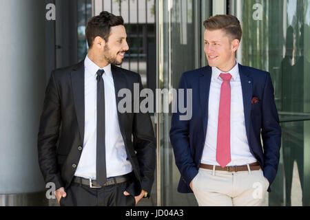 zwei hübsche Geschäftsleute Gruß einander außerhalb Stockfoto