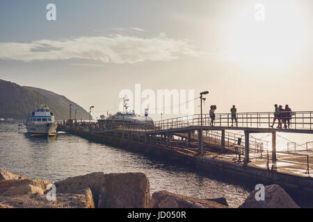 Äolischen Inseln, Lipari, Sizilien, Italien, Juni 8 / 2016. Hafen von Lipari, Hafen bei Sonnenuntergang, Touristen-Spaziergang auf der Mole. Stockfoto