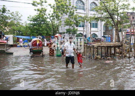 Dhaka, Bangladesch. 17. Juni 2017. Bangladeshi Menschen überqueren eine überflutete Straße am Purbo Dholaipar, Dhaka, Bangladesch, 17. Juni 2017. Vordringen der Kanäle trägt das ständige Wasser Bereich einloggen. Bildnachweis: Suvra Kanti Das/ZUMA Draht/Alamy Live-Nachrichten Stockfoto