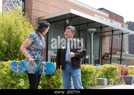 Seattle, Vereinigte Staaten von Amerika. 17. Juni 2017. Seattle, Washington: Senator des Staates und Bürgermeisterkandidat Bob Hasegawa spricht mit Brianna Davey, freiwilliger Arbeit Washington während der Beacon Hill Block Party. Der Senator, ein langjähriger Arbeit und soziale Gerechtigkeit Aktivist aus Stadtteil Beacon Hill, hat der 11. Bezirk der Legislative seit Januar 2013 vertreten. Bildnachweis: Paul Christian Gordon/Alamy Live-Nachrichten Stockfoto