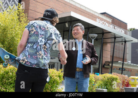 Seattle, Vereinigte Staaten von Amerika. 17. Juni 2017. Seattle, Washington: Senator des Staates und Bürgermeisterkandidat Bob Hasegawa spricht mit Brianna Davey, freiwilliger Arbeit Washington während der Beacon Hill Block Party. Der Senator, ein langjähriger Arbeit und soziale Gerechtigkeit Aktivist aus Stadtteil Beacon Hill, hat der 11. Bezirk der Legislative seit Januar 2013 vertreten. Bildnachweis: Paul Christian Gordon/Alamy Live-Nachrichten Stockfoto