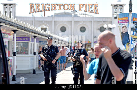 Brighton, UK. 18. Juni 2017. Bewaffnete Polizei vermischen sich mit der Öffentlichkeit über Palace Pier von Brighton in schönen warmen Sonnenschein, wie die Hitzewelle in ganz Großbritannien bis heute andauert. Sicherheit hat in Großbritannien verstärkt worden, da den jüngsten in London und Manchester Credit Terroranschlägen: Simon Dack/Alamy Live News Stockfoto