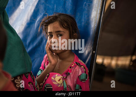 Tikrit, Irak. 16. Juni 2017. Irakische Mädchen, die in Haft gezwungen war, weil ihr Vater ein mutmaßlicher islamischer Staat Kämpfer ist sitzt vor einem Zelt auf dem Shahama ich Camp in der Nähe von Tikrit, Irak, 16. Juni 2017. Irakische Kräfte haben die Familien der vermuteten islamischer Staat (IS)-Kämpfer im befreiten Gebiet verhaften sie für eine unbestimmte Menge an Zeit routinemäßig aufgerundet. Shahama ich Campen ist das einzige Camp im Irak, die sich speziell nur Angehörigen der mutmaßliche Mitglieder der islamischen Staat hält. Sie dürfen nicht in den ummauerten Freizeitangebot. Foto: Andrea DiCenzo/Dpa/Alamy Live News Stockfoto