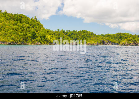 Felsige Küste der Insel von kleinen Inseln entdeckt und üppigen grünen Dschungel im bunten Meer der Fernbedienung Togean Islands (oder Togian Inseln fallen Stockfoto