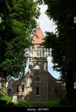 Kirche Saint Beunos, eingerahmt von einer Straße mit Bäumen und Schatten auf Steinmauern im Dorf Berriew powys Mid wales uk Stockfoto