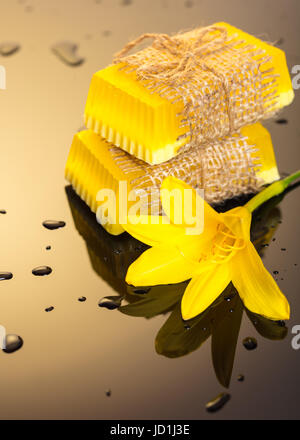 Handgemachte Seife auf einem dunklen Hintergrund mit gelben Tropfen Wasser Stockfoto