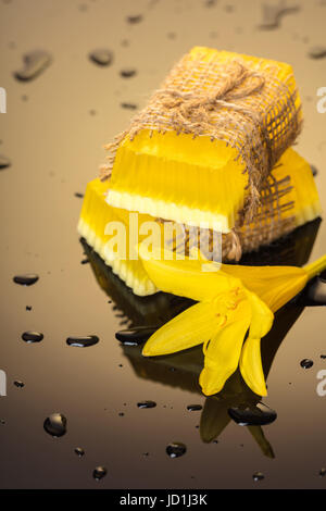 Handgemachte Seife auf einem dunklen Hintergrund mit gelben Tropfen Wasser Stockfoto