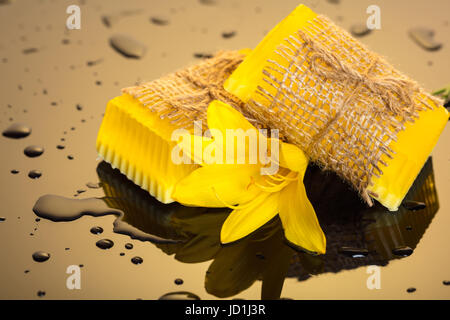 Handgemachte Seife auf einem dunklen Hintergrund mit gelben Tropfen Wasser Stockfoto