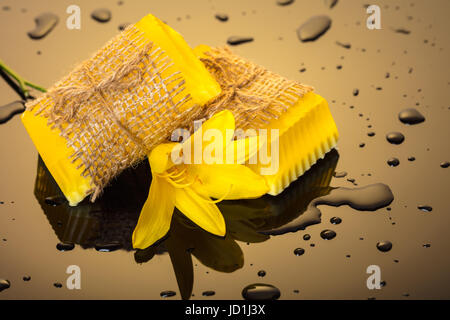 Handgemachte Seife auf einem dunklen Hintergrund mit gelben Tropfen Wasser Stockfoto