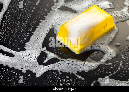 Handgemachte Seife gelb auf schwarzem Hintergrund mit Schaum Stockfoto