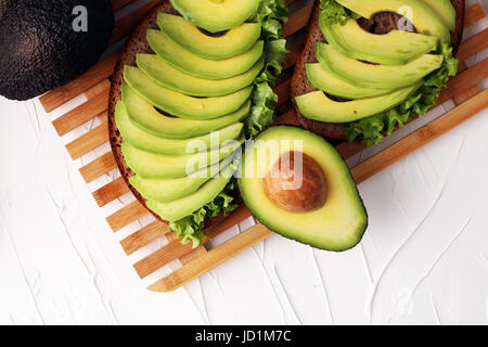 Sandwich mit Avocado und pochiertem Ei - gesundes Frühstück Konzept Stockfoto