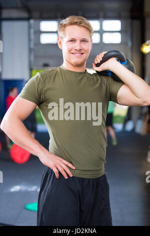 Sicher Fit Sportler halten Kettlebell im Health Club Stockfoto