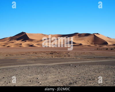 ERG CHEBBI MERZOUGA Dünen Bereich in der Nähe der Stadt und der Landschaft von Sandy Desert Formationen im Südosten Marokkos in der Nähe der Grenze mit ALGIERIA, klaren blauen Himmel. Stockfoto