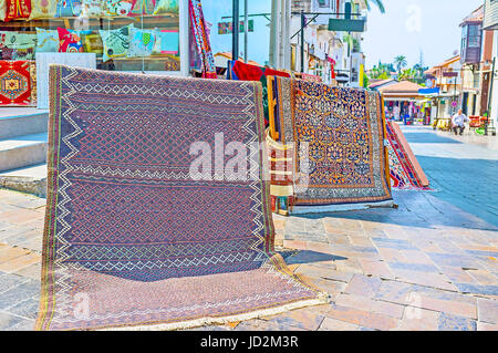 Die traditionelle türkische Teppiche ziehen die Touristen mit bunten islamischen Mustern am Eingang der Wolldecke-Speicher in der Marktstraße, Antalya, Tu Stockfoto