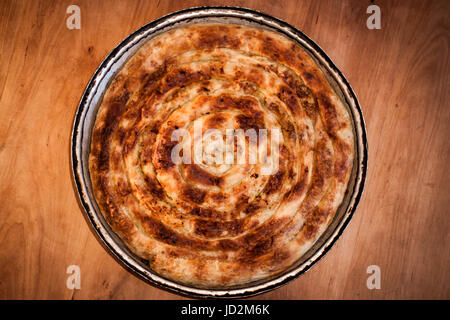 Traditionelle bosnische türkische Gericht, Pork Pie, Kuchen in der Pfanne auf einem schönen hölzernen Hintergrund Stockfoto