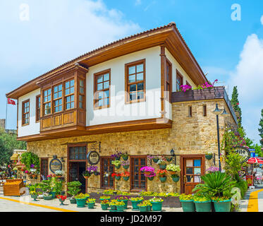 ANTALYA, Türkei - 6. Mai 2017: Das traditionsreiche Hotel im osmanischen Stadthaus dekoriert mit bunten Stiefmütterchen und Petunien in Töpfen, am 6. Mai in Antalya. Stockfoto