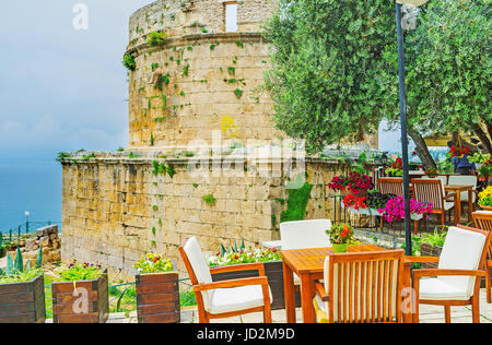 Holztische und Stühle für das gemütliche Restaurant im Freien neben dem Hıdırlık Turm - das antike Wahrzeichen erhalten seit den Zeiten der Römer, Ka Stockfoto