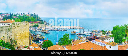 ANTALYA, Türkei - 6. Mai 2017: Der Blick von der Klippe auf die Ziegeldächer der Kaleici Viertel und die Schiffe und Boote im alten Yachthafen, am 6. Mai in Antalya Stockfoto