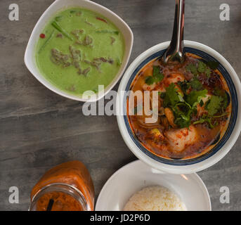 Draufsicht der thai-Food-Gerichte in Schüsseln auf einem Holztisch Stockfoto